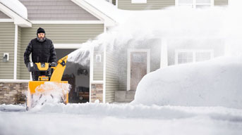 man pushing snow blower